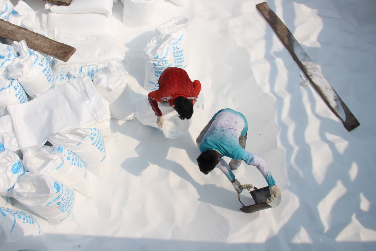 Top view of workers handling salt bags in an industrial setting.